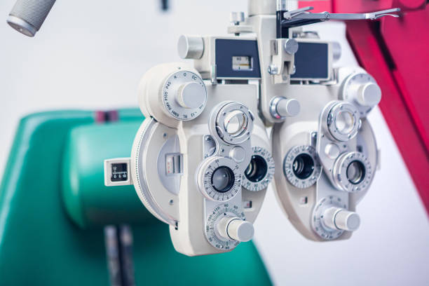 istock Optician's instrument for measuring sight. Eye test equipment. White Eye examination tool with a green ophthalmologist chair