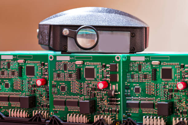 istock Closeup of Stack Batch or Line of Ready ABS Automotive Printed Circuit Boards Along With Magnifying Scrutinize Glasses in Laboratory. 1392926621