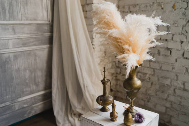 istock Golden vases, vessels and feathers in modern loft interior. 1392927157