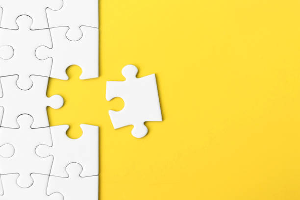 istock White jigsaw puzzle on yellow background with copy space 1392928290