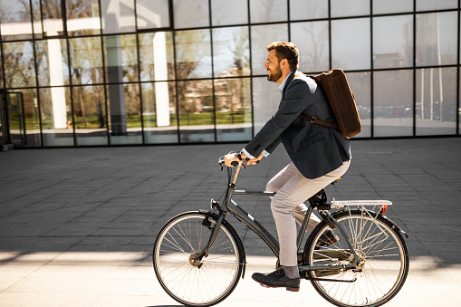 Young businessman riding his bike to his work