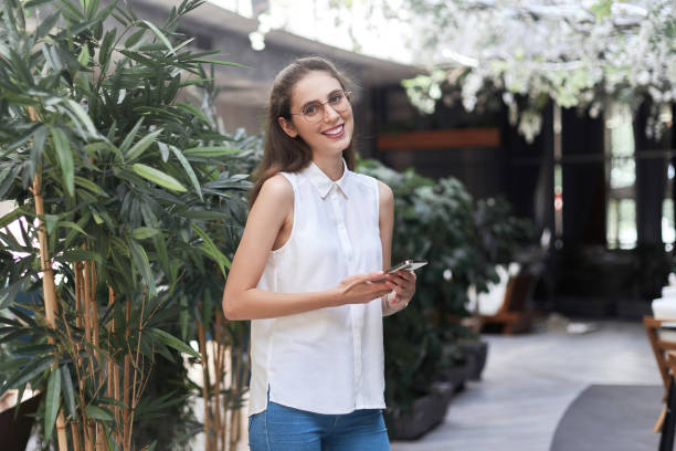 istock business woman with a smartphone standing in an empty restaurant hall 1392930168
