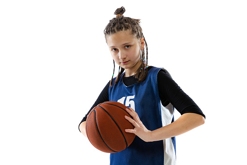 Favourite hobby. Portrait of teen girl, basketball player in uniform posing isolated over white studio background. Concept of professional sport, childhood, motion, team game, action, ad