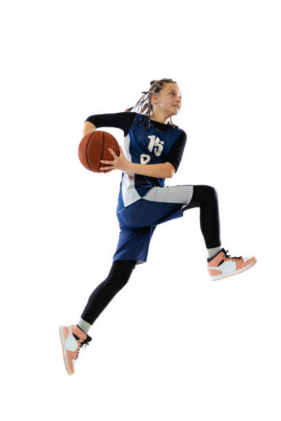 lanzar pelota en un salto. retrato de una adolescente con uniforme azul entrenando, jugando al baloncesto aislado sobre fondo blanco. - basketball sport basketball player athlete fotografías e imágenes de stock