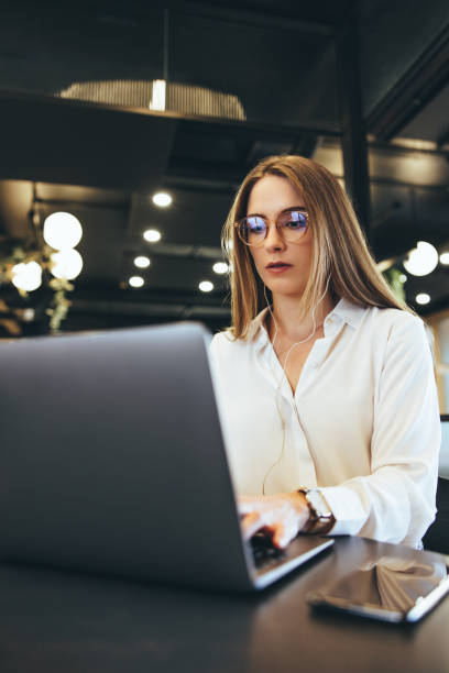 istock Young businesswoman working on a laptop in a modern workspace 1392937919