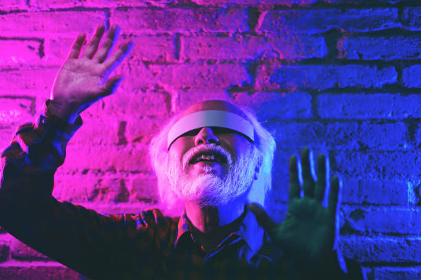 istock Happy senior man having fun using augmented reality goggles - Focus on male mouth 1392942031