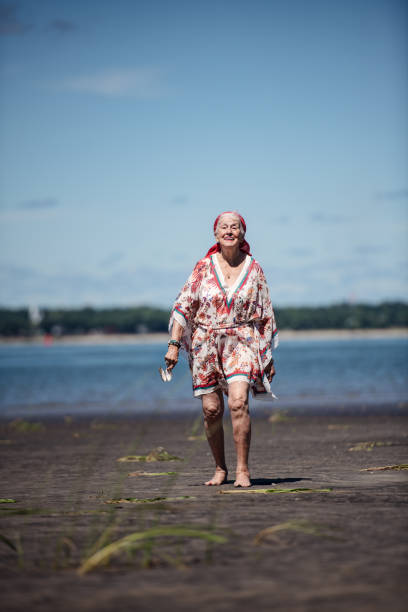 ビーチで旅を楽しむ85歳の女性 - female 80 plus years vertical people ストックフォトと画像