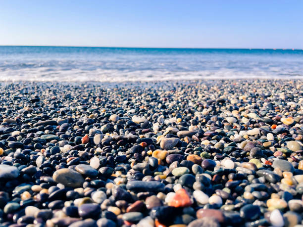 Seascape with selective focus on the colorful pebbles in the center