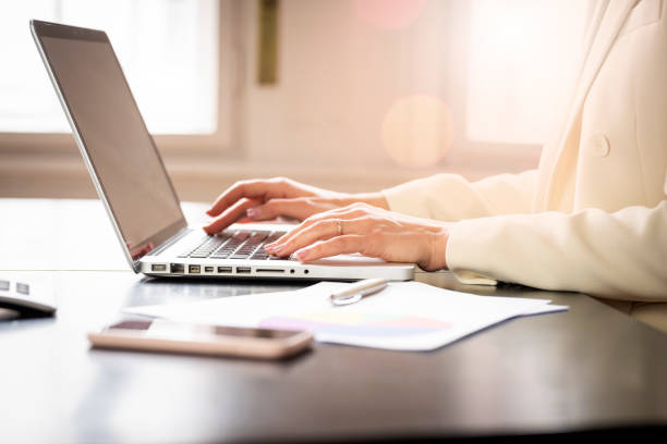 Close-up shot of inancial accountant businesswoman's hand while typing on laptop stock photo