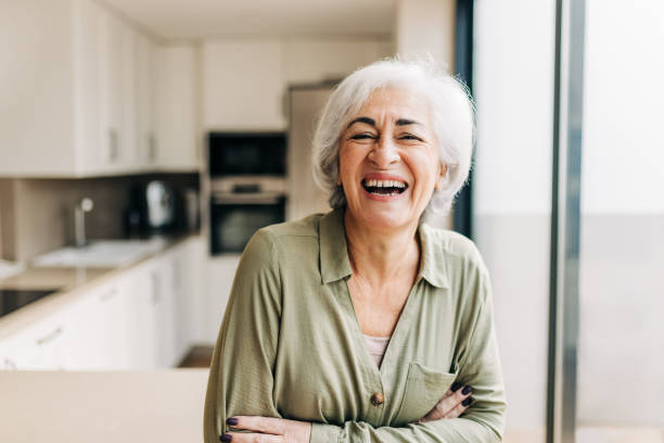 istock Cheerful elderly woman laughing happily inside her home 1392944043