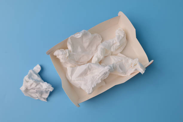 istock Crumpled tissues and paper box isolated on a blue background 1392947584