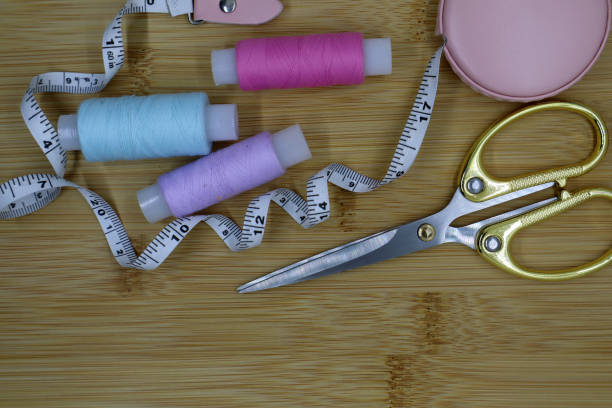 istock Set of sewing accessories on a wooden background. Fabric, threads, centimeter and scissors. 1392949860