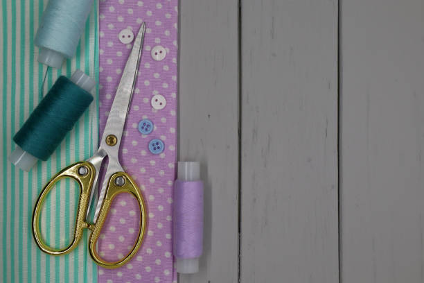 istock Set of sewing accessories on a grey wooden background. Fabric, threads and scissors. 1392949947