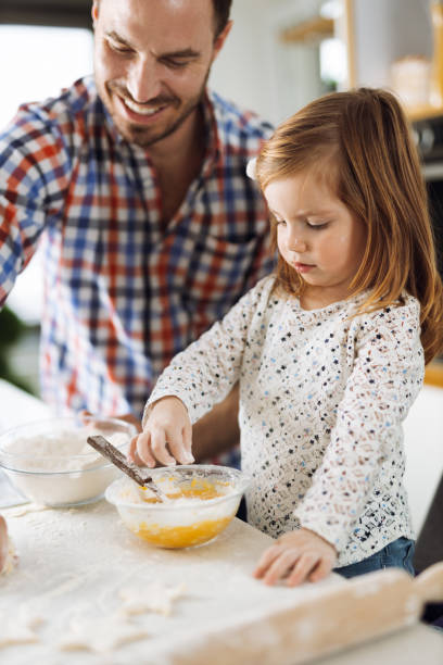 istock Little girl and her father baking in the kitchen 1392954839
