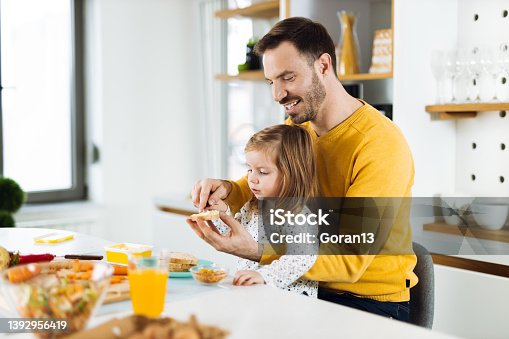 istock Happy father and daughter making breakfast in the kitchen 1392956419