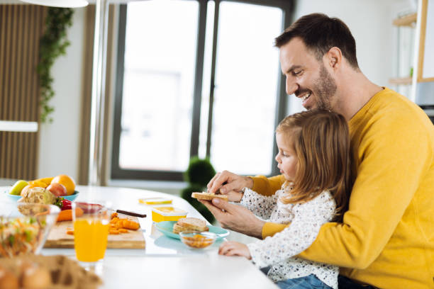 istock Happy father and daughter making breakfast in the kitchen 1392957578