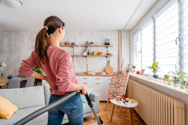istock Young Woman Vacuuming Her Apartment 1392969170
