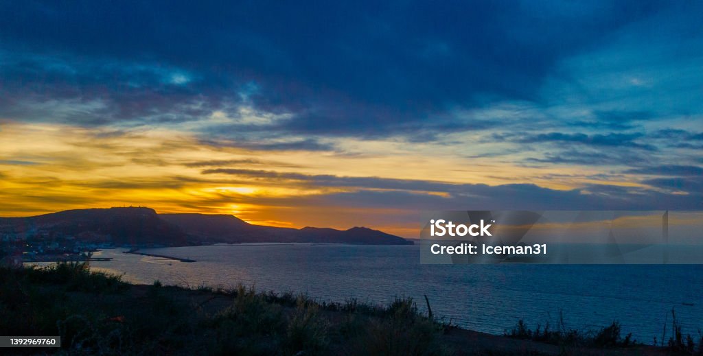 sunset above the sea, dramatic sky and sunset above the coast of Oran with moutains in the background dramatic sky and sunset above the coast of Oran with moutains in the background Abstract Stock Photo