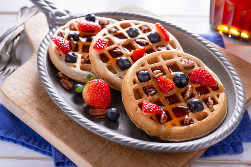 Belgian waffles on a plate with chocolate for breakfast on a napkin. Fast snack