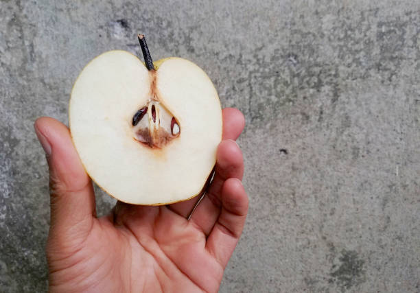 istock Hands holding a slice of pear fruit 1392974125