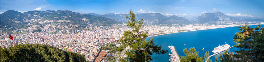 Alanya harbour, Alanya TurkeyAlanya - Antalya, Turkey, April 17th 2022: Alanya Castle is one of the symbols of Alanya, the district of Antalya. It is located on a peninsula rising approximately 250 meters from the sea. The length of its walls is 6.5 kilometers in total. The road passing through the walls was built in the settlement of Alanya, which was called Kandeleri in ancient times, during the Hellenistic period. The history of the castle, which is a 13th century Seljuk artifact, dates back to the Hellenistic period. \nThe castle was built by Seljuk Sultan Alaeddin Keykubad I, who took the city and had it rebuilt in 1221. There are 83 towers and 140 bastions in the castle. In the Middle Ages, about 1200 cisterns were built to meet the water needs of the city, which was inside the walls. Some of the cisterns are still in use. The walls were built in a planned manner, passing the Tophane and Tersane, and ending in Kızılkule, following Ehmedek, İçkale, Adam Atacak, Cilvarda cape, Arap Evliyası and Esat Bastion.