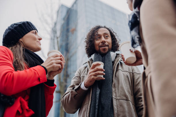 istock Businessman is talking with his colleagues in front of an office building while drinking coffee 1392980597