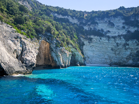 Beautiful view of the blue cave of Paxos island. The purest water with an amazing turquoise hue. Corfu, Greece.