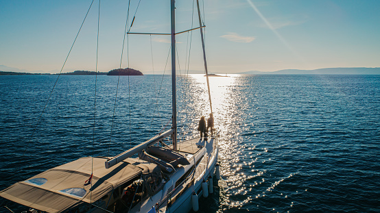 sailing boat in open sea at sunset, beautiful luxurious yacht crossing ocean