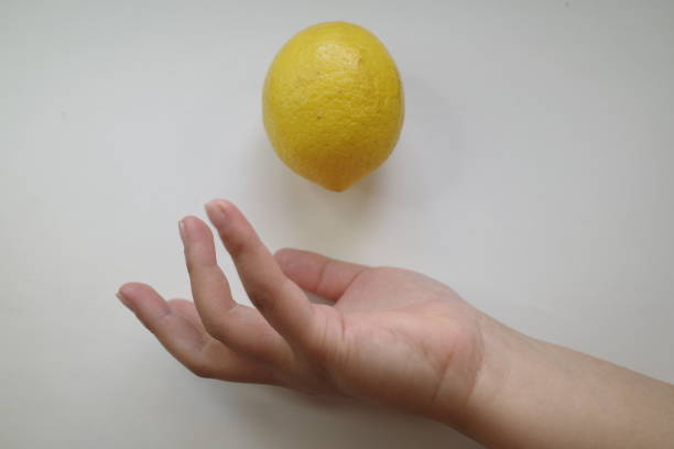 The action of throwing lemon by hand is on a white background