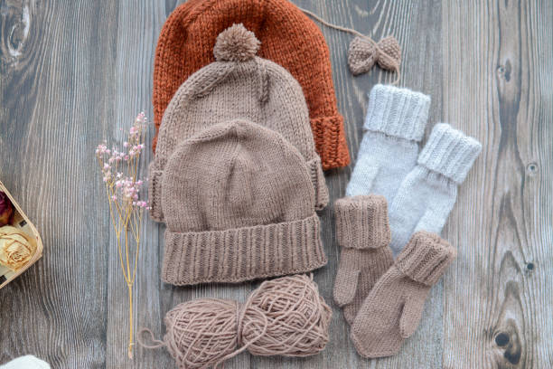 istock New handmade project, woolen mittens and hat, on dark wooden background 1392983723
