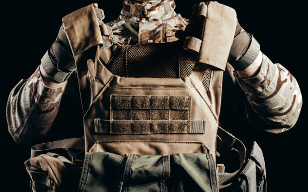 soldado con guantes sosteniendo chaleco antibalas miltary. - waistcoat fotografías e imágenes de stock