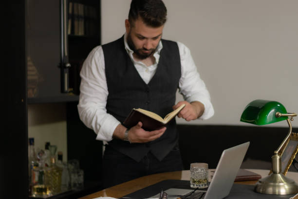 istock Businessman reading his notebook looking at his notes trying to find the solution that he needs, working late at his office until the night 1392985609