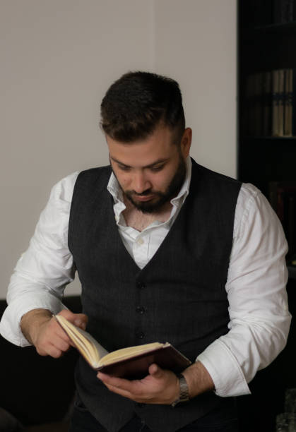 istock Businessman reading his notebook looking at his notes trying to find the solution that he needs, working late at his office until the night 1392985614