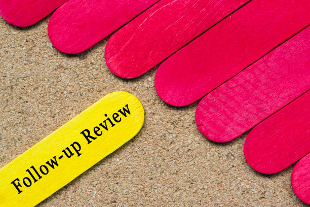 Follow-up review text on yellow color wooden stick. Business concept. stock photo