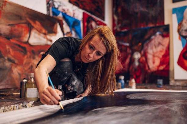 istock Female painter artist painting and creating her art in a creative studio 1392987184