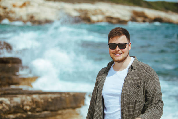 istock young man in sunglasses with beard portrait at seaside 1392988649