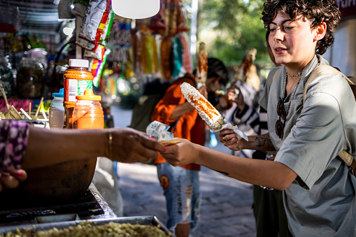 Woman paying for her food at street food corner