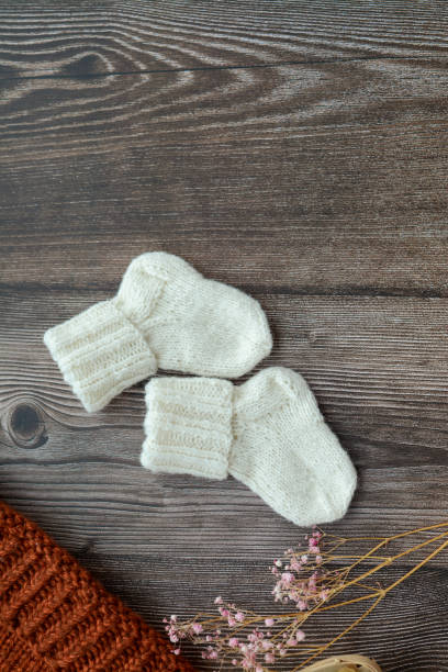 istock Small woolen baby socks, on dark wooden background 1392992377