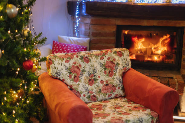 istock Empty armchair by Christmas tree and fireplace at home 1392992398