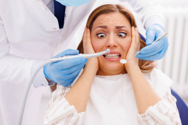 istock Afraid woman at dentist office 1392993957
