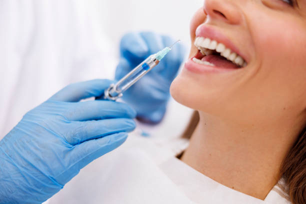 Dentist applying local anesthetic to patient stock photo