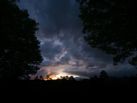 storm cloud gathering during sunset at rural scene during sunset