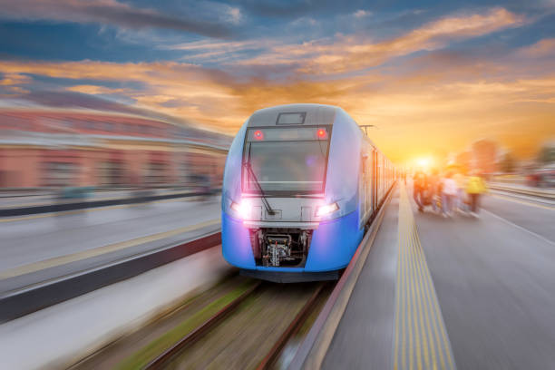 railway station with modern high speed red commuter train with motion blur effect at colorful beautiful sunset. - high speed train imagens e fotografias de stock