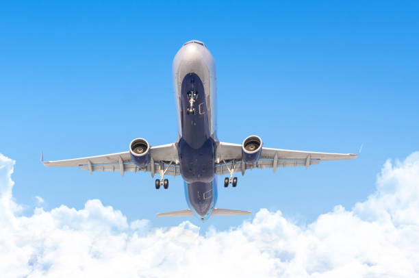 istock Passenger liner flying overhead in the sky with clouds. 1392995950