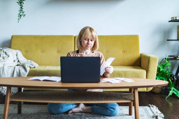 istock Young woman handling personal finance at home using laptop 1392995990