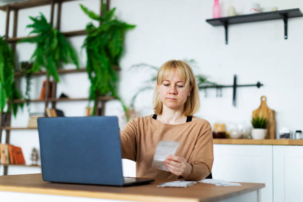 istock Young woman handling personal finance at home using laptop 1392995994