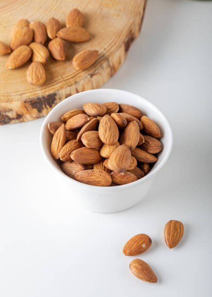 istock Almonds in white bowl on white background. 1392997747