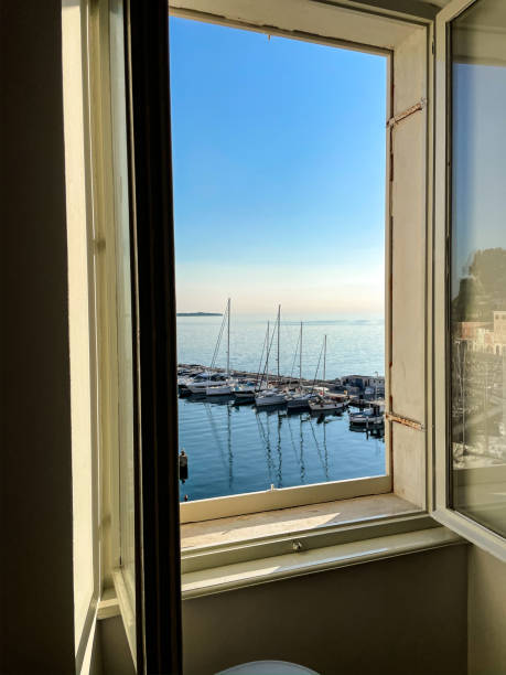 istock Boats moored at harbor against clear sky seen through window 1392999371