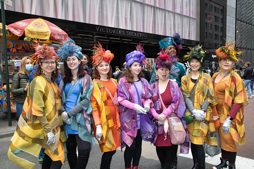 New York City, NY- April 17, 2022: A group of women in similarly themed costumes, pose for the crowd on Fifth Avenue during the annual Easter Bonnet Parade.