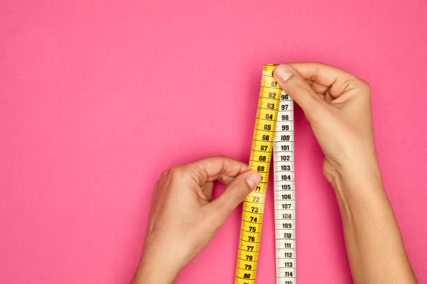 istock Woman Holding Tape Measure 1393002998